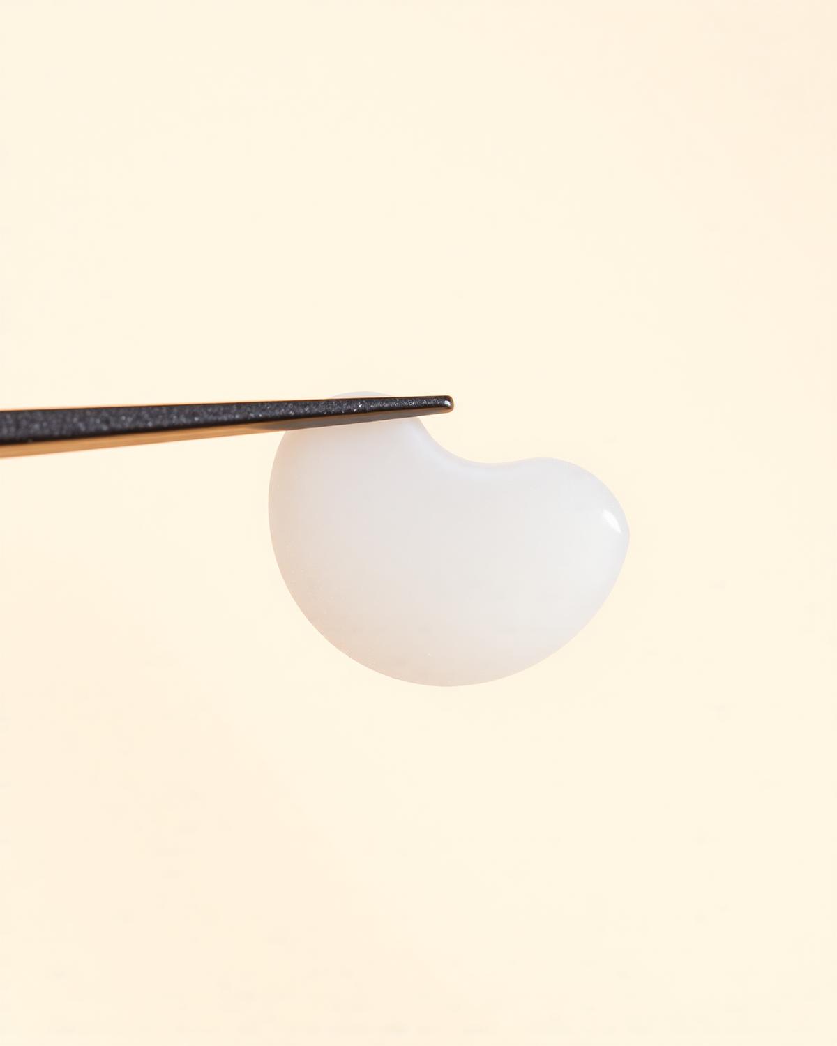 A single ultra-thin porcelain veneer held by tweezers